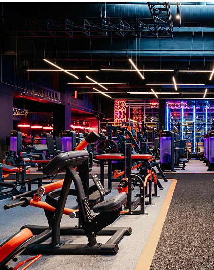 Просторий тренажерний зал з сучасним обладнанням, неоновим освітленням та панорамними вікнами