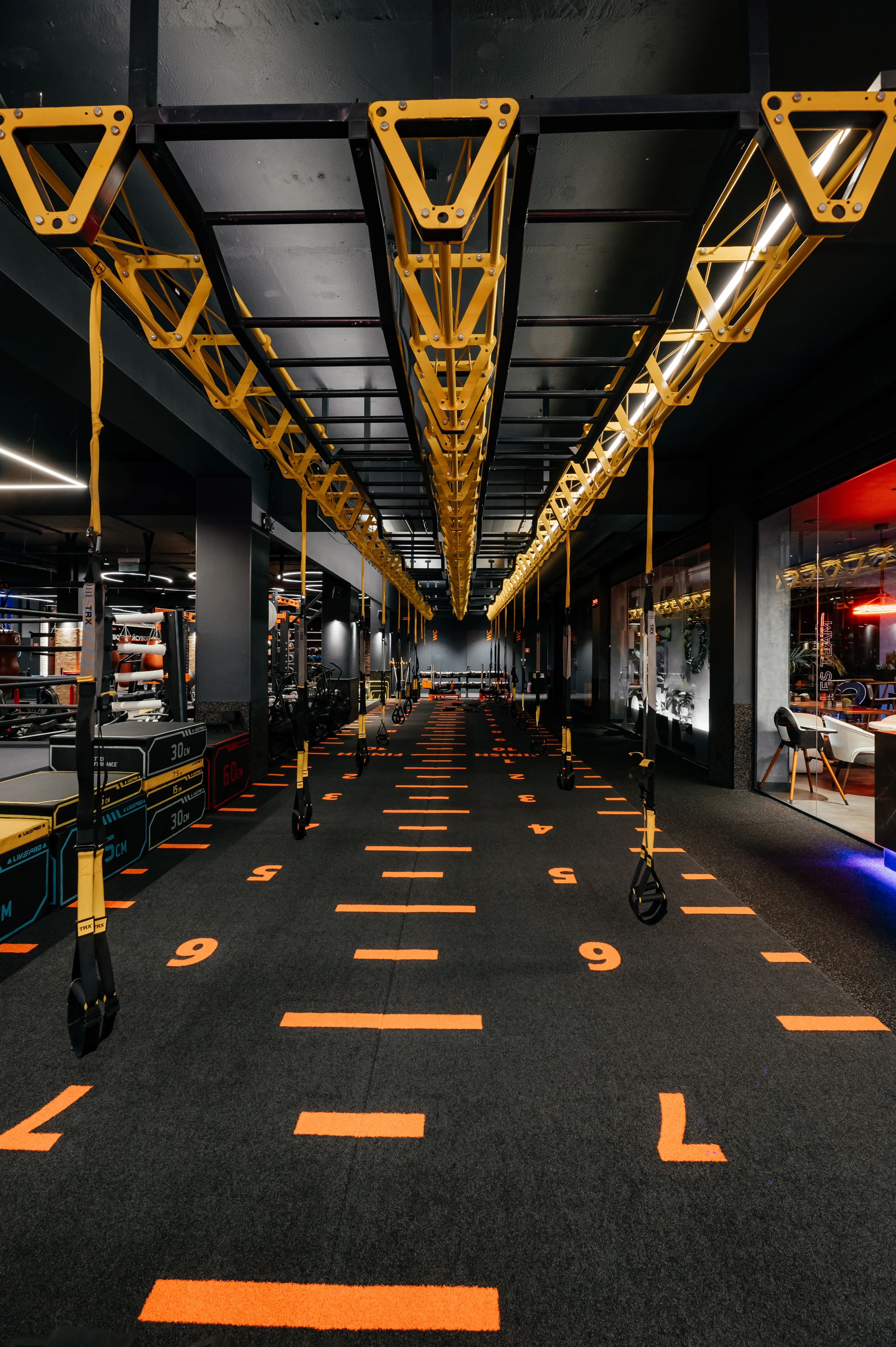 Композиція з силовим тренажером з яскравим кольоровим контрастом та мотивуючим написом на стіні